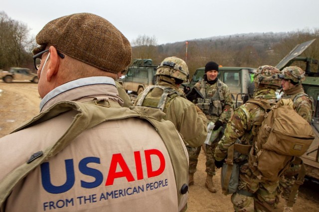 A representative from USAID waits for a convoy as Staff Sgt. Dylan Ruefle, 25, of Pittsburgh, Penn., a noncommissioned officer from the U.S. Army Reserve’s 303rd Psychological Operations Company, briefs U.S. and Hungarian Soldiers prior to a mission during Allied Spirit 22 in the Joint Multinational Readiness Center training area near Hohenfels, Germany. 