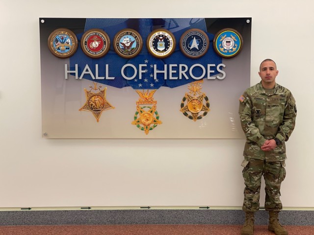 Staff Sgt. Gabriel Franco-Heredia poses in front of a mural at the Hall of Heroes at the Pentagon. 