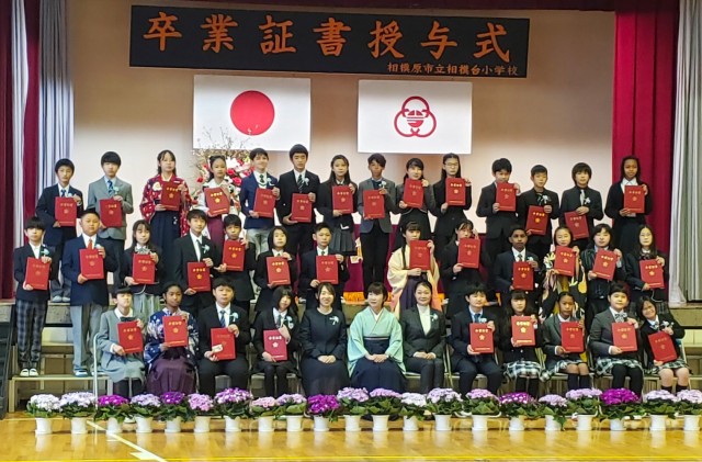 Abigail Ray, far right in the top row, attends a graduation ceremony after completing sixth grade at a Japanese school.  She now attends seventh grade at Sagamidai Junior High, where her older sister, Naomi, also attends.
