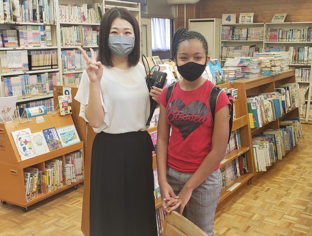 Abigail Ray poses for a photo with one of her teachers at a Japanese school. Ray now attends seventh grade at Sagamidai Junior High, where her older sister, Naomi, also goes.