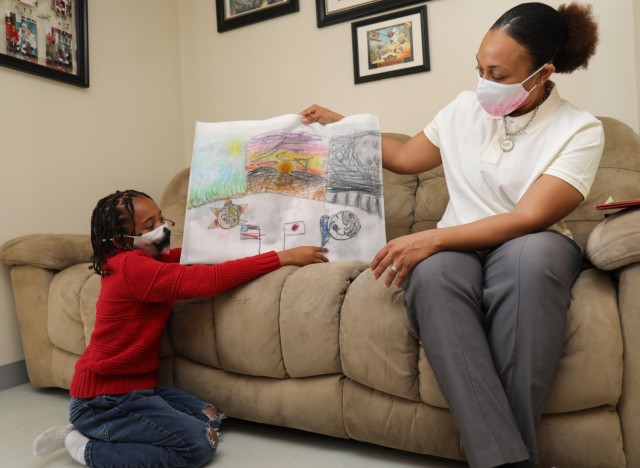 sergeant.  1st Class Georgette Ray watches her son, Roderick Jr., who attends Sagamidai Elementary School, show off his artwork he created while attending the Japanese School near the family housing area of Sagamihara, Japan on March 25, 2022.