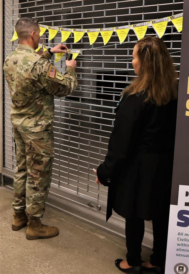 Fort Knox Garrison Commander Col. Lance O’Bryan hangs his pledge pennant on the garland displayed at the Main Exchange April 6, 2022 after signing it as part of the ‘I pledge campaign’ for Sexual Assault Awareness and Prevention Month.