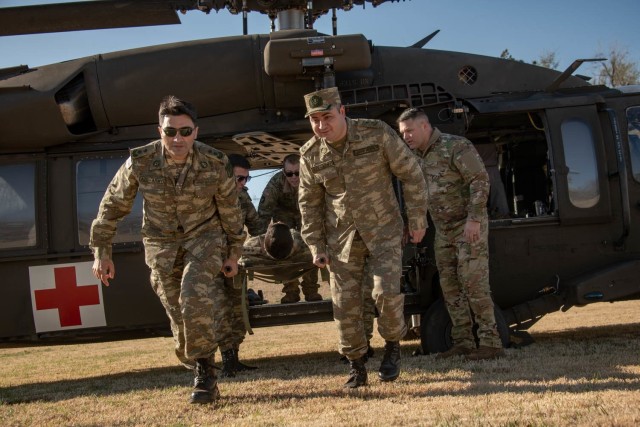 Oklahoma Army National Guard Soldiers and doctors with the Azerbaijan Operational Capabilities Concept Battalion evacuate a simulated patient from a UH-60 Black Hawk helicopter during a medical knowledge exchange in Oklahoma City, April 1, 2022, in support of the Department of Defense National Guard Bureau State Partnership Program.