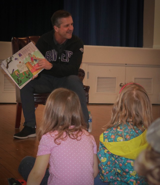 Head Coach of the Baltimore Ravens John Harbaugh reads “The World Needs More Purple People” to children during the annual Tell Me a Story event at the APG north recreation center March 31.
