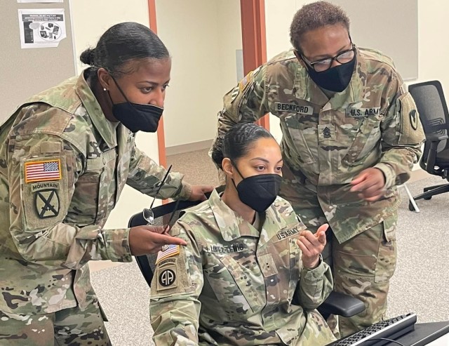 Sgt. Maj. Kimala Cox,  a member ACC exercise control group, and Cmd. Sgt. Maj. Angella Beckford, command sergeant major for the 413th CSB, discuss a property issue  regarding contract administration services with Chief Warrant Officer 2 Yalena Lopez-Lewis, the property administration officer in charge for 411th CSB.