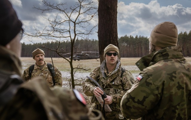 Chief Warrant Officer 2 Joey White, a UH-60 Blackhawk helicopter pilot from the 1-214th General Support Aviation Battalion, 12th Combat Aviation Brigade briefs the group of soldiers from the 1-214th GSAB, 12 CAB and the Polish Armed Forces during a personnel recovery exercise at the Nowa Deba Training Area, Poland, April 4, 2022. This exercise and others like it enhances our interoperability with our NATO allies and partners strengthens the regional relationships that we have developed. 12 CAB is the only enduring aviation brigade present throughout Europe that enables us to deter and defend against threats from any direction. (U.S. Army photo by Staff Sgt. Thomas Mort)