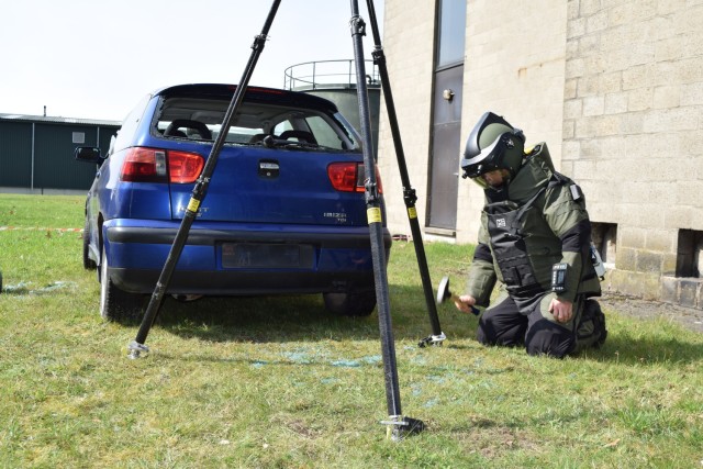 Belgian bomb squad member suits up to approach mock car bomb in exercise