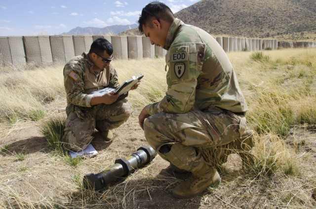Sgt. Cole Ladrini looks at an unexploded device (represented by an inert practice item) while Staff Sgt. Casey Benevidez looks up information about the weapon on an EOD database. EOD soldiers have access to special tools like this database that allow them to look up information about different explosive devices from all over the world to determine how best to dispose of them.