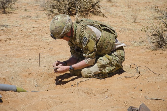 Staff Sgt. John Bradshaw, an EOD technician with the 630th Ordnance Company out of Fort Riley KS places a small explosive next to a simulated bomb. EOD often has to use smaller explosives to destroy key components of explosive devices to make them safe to move and properly destoy in safer location.