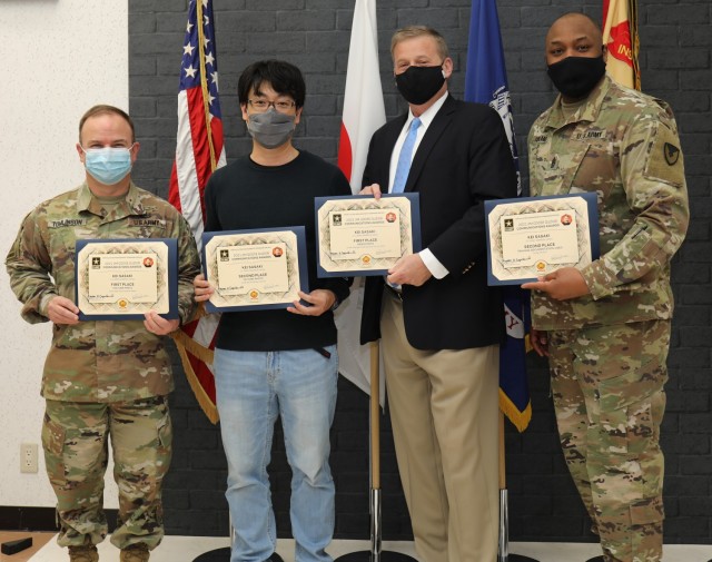 Kei Sasaki, second from left, poses for a photo with his certificates during an awards presentation at Camp Zama, Japan, April 14, 2022. Col. Christopher L. Tomlinson, left, commander of U.S. Army Garrison Japan; Craig L. Deatrick, director of...