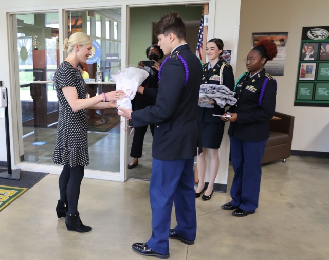 Students present Kentucky First Lady Britainy Beshear with flowers and Fort Knox Middle High School apparel during her Month of the Military Child visit April 14, 2022.
