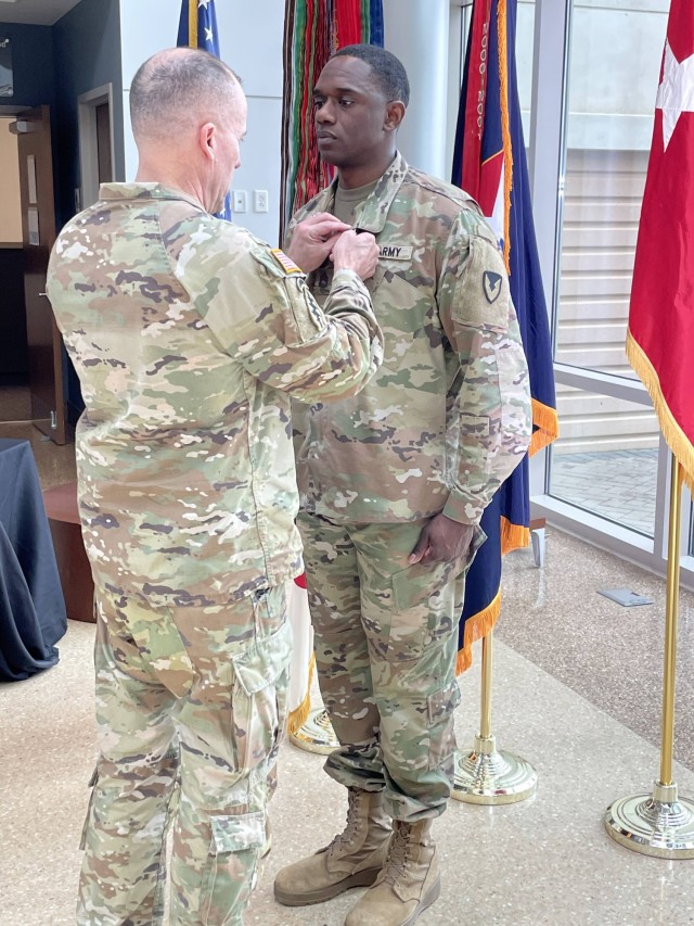 Maj. Gen. Walter M. Duzzny, U.S. Army Materiel Command&#39;s chief of staff, pins an Army Commendation Medal on Sergeant 1st Class Sanqwey Walker, career counselor for Army Contracting Command April 6. Walker won the first ever AMC Soldier Career Counselor of the Year competition.