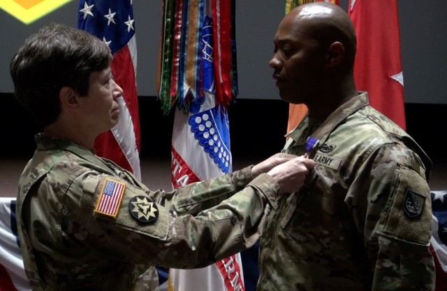 : (left)  Maj. Gen. Maria Barrett, Commander General, U.S. Army Network Enterprise Technology Command presents the Purple Heart to Staff Sgt. Charles Gipson for wounds he received during an Iranian missile attack while forward deployed to  Al-Asad Air Base, Iraq. 