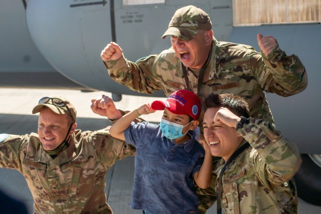 Texas Air National Guard Master Sgt. Jarrett Patman, left, Tech. Sgt. Kevin Hannah, middle, and Staff Sgt. Ivan Castañeda, right, take photos with the public by the C-130J Super Hercules static display at the Feria Internacional del Aire y Espacio (FIDAE) April 9, 2022, in Santiago, Chile.  Airmen from the 136th Airlift Wing attended the air show to strengthen international partnerships. (U.S. Air National Guard photo by Senior Airman Laura Weaver)