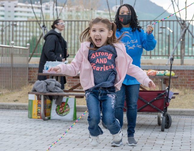 Lisa Evergin (right) looks on as a young resident of U.S. Army Garrison Daegu&#39;s Army Family Housing towers enjoys a spring day of Double Dutch at Camp Walker, Republic of South Korea, April 1, 2022. The community-organized event helped kick off Month of the Military Child observances for USAG Daegu. Month of the Military Child is observed each April to honor military children for their service and sacrifice in support of the Army&#39;s mission.