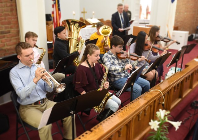 The seven teenage military children who comprise the Main Post Chapel orchestra perform the Hallelujah Chorus at Easter Sunday service together with a pianist and their orchestra leader.