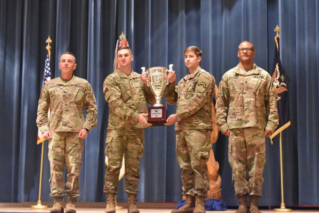 Col. Sean Crockett, U.S. Army Chemical, Biological, Radiological and Nuclear School commandant (left), and USACBRNS Regimental Command Sgt. Maj. Christopher Williams (right) stand on stage April 15 at Baker Theater with 1st Lt. Jordan Anderson (left, holding trophy) and Sgt. Austin Howard, from the 2nd Battalion, 75th Ranger Regiment at Joint Base Lewis-McChord, Washington. Anderson and Howard were the winners of the six-day Best CBRN Warrior competition, held here from April 11 to 15. 