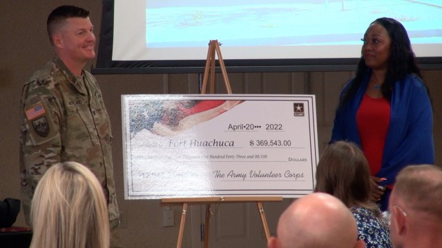 Col. Jarrod Moreland, Commander, U.S. Army Garrison-Fort Huachuca, and Teresa Spencer, Army Emergency Relief Officer unveil a check symbolizing 12,948.25 volunteer hours totaling $369,543 worth of manpower donated to the Post.