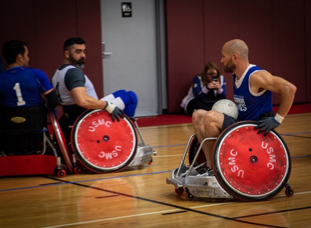 Retired U.S. Staff Sgt. Shawn Runnells, Team U.S., carries a ball at wheelchair rugby practice, during the Invictus Games Team U.S. Training Camp at Fort Belvoir, Virginia on April 10, 2022. Team U.S. is part of more than 500 participants from 20 countries who will take part in this multi-sport event featuring ten adaptive sports, including archery, field, indoor rowing, powerlifting, swimming, track, sitting volleyball, wheelchair basketball, wheelchair rugby, and a driving challenge.