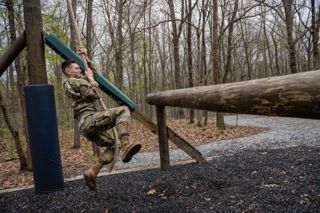 A military police officer swings on a rope in the air assault obstacle course portion of the second annual Fort Knox Top Cop Competition April 21, 2022.