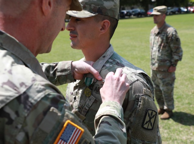 Maj. Gen. JB Vowell, commander of U.S. Army Japan, pins the Expert Soldier Badge on Staff Sgt. Daniel Gomez, assigned to 78th Signal Battalion, during an award ceremony at Sagami General Depot, Japan, April 22, 2022.  Twenty-three Soldiers earned the coveted badge after a grueling weeklong competition, which initially had about 120 participants in USARJ’s first-ever testing event for the newest skill badge in the Army.