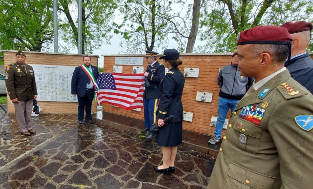 U.S. Army and Air Force personnel joined Italians at Poggio Rusco April 24, 2002, to unveil a plaque for the U.S. personnel who took part in Operation Herring. Officials removed a U.S. flag uncovering the plaque. Pictured, from left; 1st Sgt. Jonathan Risher, Fabio Zacchi, the Poggio Rusco Mayor, Cpt. Joseph Hart, U.S. Army Garrison Italy, Maj. Evette Barnes, U.S. Army Garrison Italy’s executive officer and Col. Vincenzo Zampella, 183rd Parachute Regiment.  