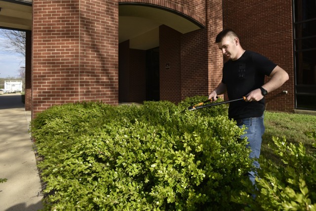 2nd Lt. Jacob Fries, an Engineer Basic Officer Leader Course student with Company B, 554th Engineer Battalion, helps trim the bushes outside the Maneuver Support Center of Excellence building Saturday, in support of the Earth Day and National Volunteer Week clean up event here. 