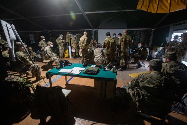 Italian soldiers assigned to 11th Bersaglieri Battalion review an operation order with Observer Coach Trainers at the Joint Multinational Readiness Center in Hohenfels Training Area on Feb. 19, 2021. Combined Resolve XV not only highlights the relationship between the 1st Armored Brigade Combat Team of the 1st Calvary Division and our partners and allies, but also our commitment to those same partners and allies.  (U.S. Army photo by Spc. Uriel Ramirez).