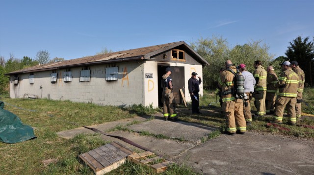 Firefighters from six different departments are briefed outside the structure where they will soon be battling flames as part of a multi-department training exercise April 27, 2022 at Fort Knox.