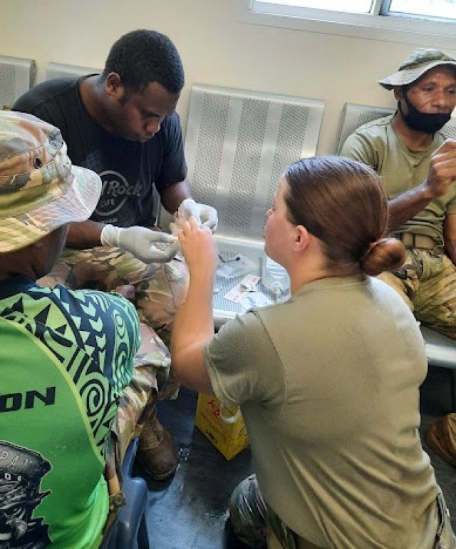 220412-Z-DA841-3510 -- Wisconsin Army National Guard Spc. Samantha Struck demonstrates how to insert an IV during a medical class with the Papua New Guinea Defense Force at Taurama Barracks, Port Moresby, Papua New Guinea, in March 2022. The Wisconsin Guard and Papua New Guinea are partners under the Department of Defense National Guard State Partnership Program. 