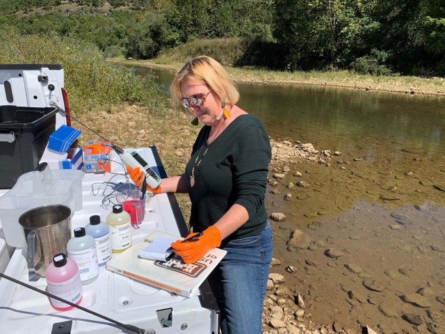Heather Williams, FLW stormwater manager, is shown sampling surface water.  FLW’s industrial stormwater permit requires sampling and recording of field parameters such as pH and dissolved oxygen. To ensure the surface water remains high quality, FLW continuously checks for contaminants both visually and analytically in multiple locations on the installation. Water quality is one of FLW’s most significant environmental aspects.