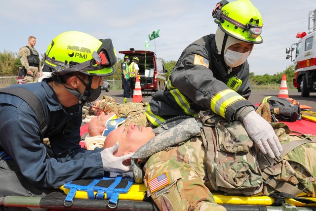 Firefighters from the U.S. Army Garrison Japan Fire Department practice lifesaving techniques on Chief Warrant Officer 4 Joseph Mattos, one of the pilots during a mock aircraft crash at Kastner Airfield, Camp Zama, Japan, April 28, 2022.