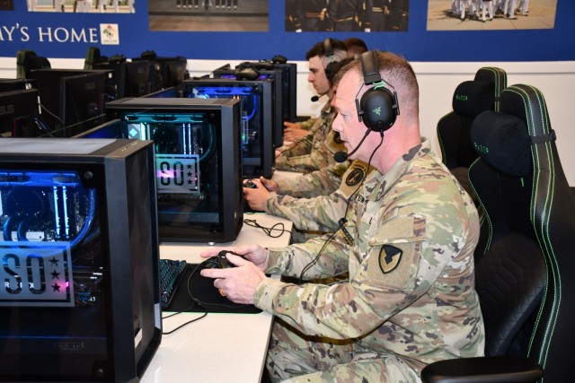 Joint Base Myer-Henderson Hall Commander Col. David Bowling plays video games with service members at the USO Honor Guard Lounge Gaming Center April 22.