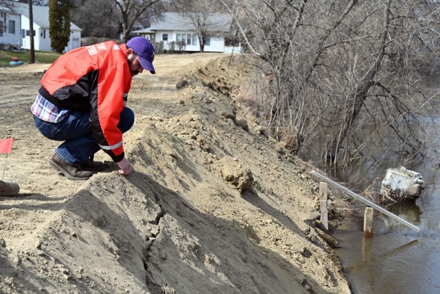 Adam Gamblin, U.S. Army Corps of Engineers, St. Paul District, geotechnical engineer, examines a vulnerable area on a temporary levee within Valley City, North Dakota, April 28.  
Gamblin is among a team of engineers that are routinely looking at vulnerable areas within the community. They are positioned to rapidly respond to an area if a situation develops that needs to be addressed.
The U.S. Army Corps of Engineers, St. Paul District, and its contractor, Strata Corporation, from Grand Forks, North Dakota, completed around 8,000 linear feet of temporary levees to enhance protection within the community from the Sheyenne Rivers following recent weather events within the region. Corps officials completed the temporary levee construction April 26, ahead of the Sheyenne River cresting early next week. Corps officials are in coordination with their federal, state and local partners as the city monitors the levee system.  

