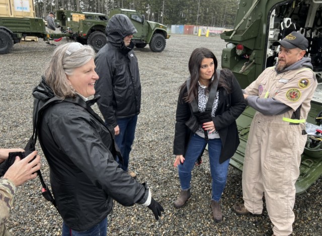 Port of Olympia Community Connectors (L-R) Sam Gibboney, Executive Director, Bob Iyall, Commissioner, and Jennie Foglia-Jones, Marketing and Communications Director, don safety gear under the guidance of Army Materiel Command RLRC yard personnel. 