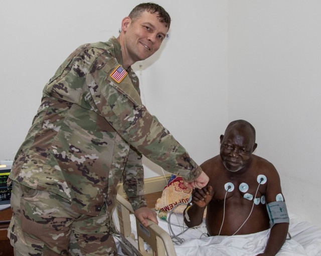 U.S. Army Capt. Matthew Gomberg, a battalion physician assistant assigned to Headquarters and Headquarters Company, 3rd Battalion, 126th Infantry Regiment, Michigan National Guard, with a cardiac patient in 14 Military Hospital in Monrovia,...
