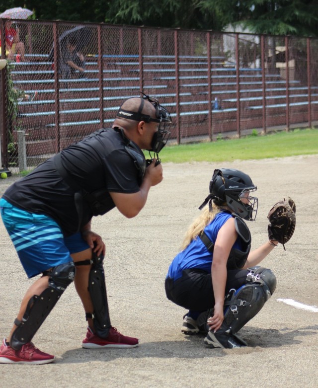 Kekua Aumua, left, a supervisory air traffic control specialist at Kastner Airfield, serves as an umpire for a youth softball game. Aumua often volunteers to assist youth sports as part of his efforts to help the community.