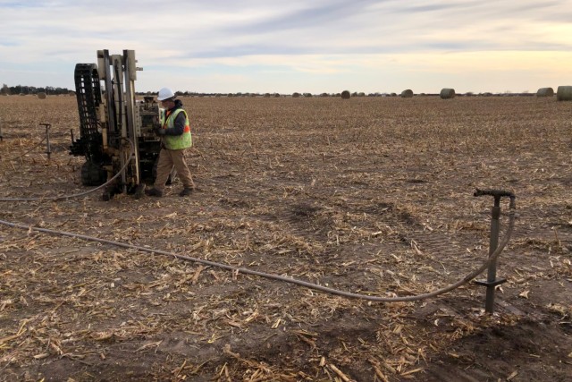 Drill rods with hose connections are set at injection locations. The drill crew checks the connection before injections begin. Hoses containing amendment mixture are routed from holding tanks to injection locations.