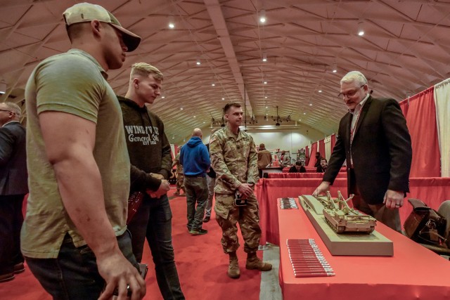 Capt. Aleksandrs Schuler, an Engineer Captains Career Course instructor (center), speaks with one of the nearly 40 defense contractors and industry partners on hand April 27 at Nutter Field House for the Army Engineer Association industry exhibition.