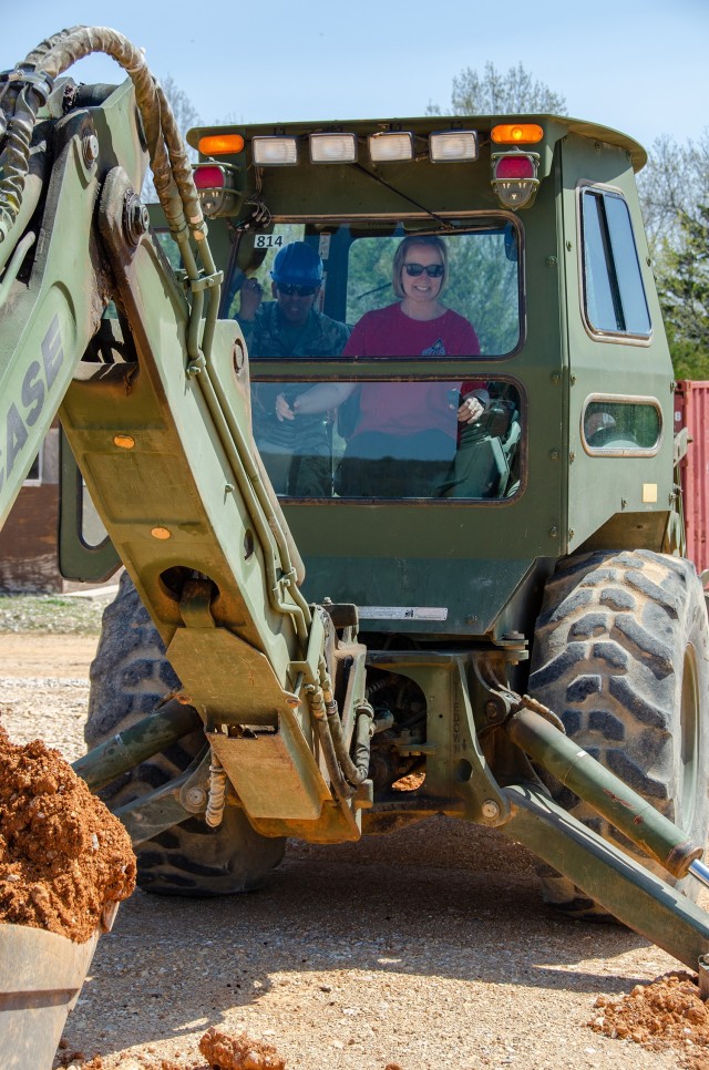 Heidi Grabowski – spouse of Lt. Col. John Grabowski, 31st Engineer Battalion commander – operates a backhoe loader while Staff Sgt. Byron Lobos, Company A, 554th Engineer Battalion, supervises during the Engineer Family Day April 27 at Training Area 244. The event gave spouses and family members the chance to learn more about what it’s like to be an Army Engineer.