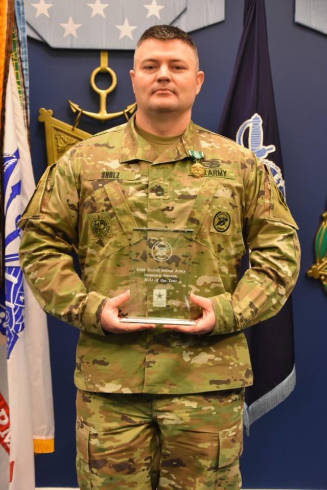 U.S. Army Sgt. 1st Class Andrew Sholz, an inspector general noncommissioned officer in charge with the 3rd Infantry Division at Fort Stewart, Georgia, holds his award after being named the Army Inspector General of the Year in the NCO category at the Pentagon in Arlington, Virginia, April 20, 2022. 

