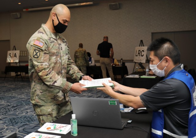 Master Sgt. Christopher Hirata, left, the operations sergeant for the Directorate of Plans, Training, Mobilization and Security, completes one of the stations during an Emergency Evacuation Program drill inside the Camp Zama Community Club, Japan,...