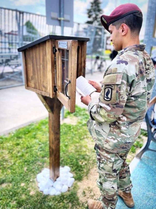 A paratrooper waiting to go into the Central Processing Facility checks out the free library, reminiscing about some of his favorite childhood books.