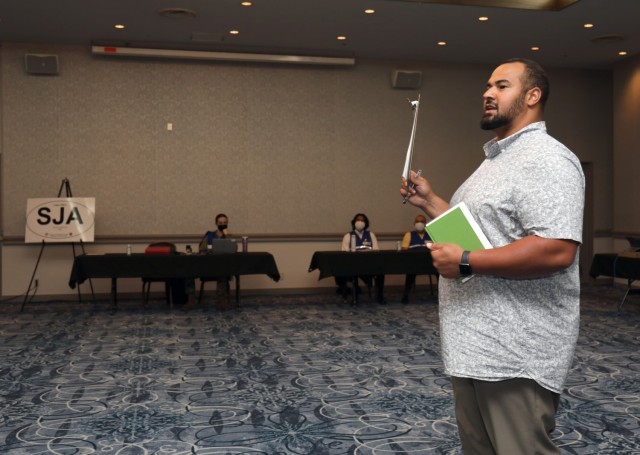 Mikael Merrick, manager of the Emergency Evacuation Program, speaks with key enablers before a drill inside the Camp Zama Community Club, Japan, May 9, 2022.
