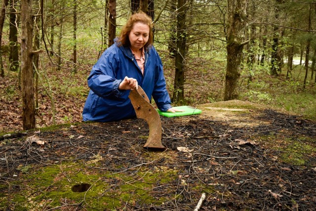 Archeologist Stephanie Nutt, with the Fort Leonard Wood Cultural Resources Program, inspects an artifact found at an archeological site on Fort Leonard Wood. Artifacts are usually left in place, unless they are at risk of destruction due to being...