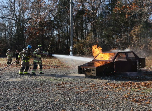 One of five Fort Knox Middle High School Class of 2022 seniors participating in the 150-hour firefighter certification program works to extinguish flames in a simulated car fire Nov. 19.