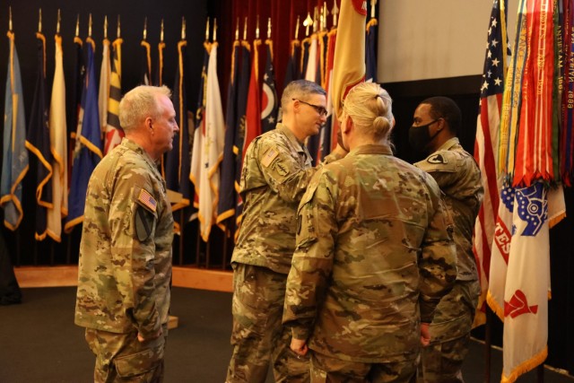 Col. Matthew Kelly receives the US Army Environmental Command colors from IMCOM CG Lt. Gen. Gabram and passes them to USAEC&#39;s Command Sgt. Maj. Trey Robbins, symbolizing his assumption of command.