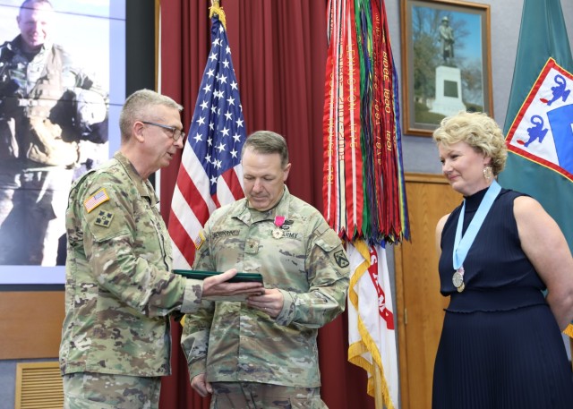 Combined Arms Center Commanding General Lt. Gen. Theodore Martin presents Combined Arms Center-Training Deputy Commanding General Brig. Gen. Charles Lombardo with the Legion of Merit during Lombardo’s farewell and award ceremony May 11, 2022 in Grant Auditorium, Fort Leavenworth, Kan. Kristy Lombardo (right) had also just received the Outstanding Civilian Service Award and the Margret C. Corbin Award. Photo by Tisha Swart-Entwistle, Combined Arms Center-Training Public Affairs.