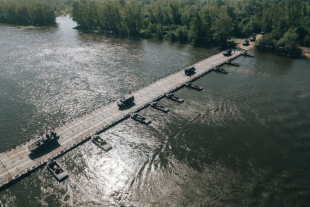 A float ribbon bridge system from the Army Prepositioned Stocks-2 worksite in Zutendaal, Belgium, is used by U.S., Polish, French and Swedish military forces to cross the Vistula River between Ryki and Kozienice, Poland, during DEFENDER-Europe 22, May 13. The float bridge is part of the 405th Army Field Support Brigade’s APS-2 program. This was the first time a float bridge system from the Zutendaal APS-2 site was transported to Poland and used during a DEFENDER-Europe exercise.