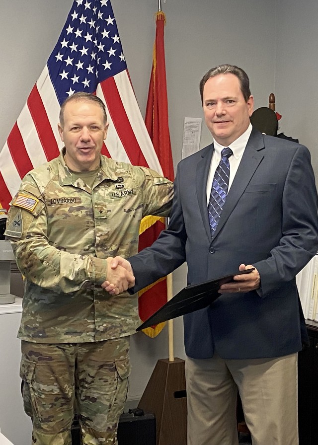 Combined Arms Center-Training Deputy Commanding General Brig. Gen. Charles Lombardo congratulates Richard Robinson from the Combat Training Center Directorate after presenting him with a certificate of recognition during the CAC-T all-hands meeting May 11, 2022 in the CAC-T Headquarters, Fort Leavenworth Kan. Photo by Tisha Swart-Entwistle, Combined Arms Center-Training Public Affairs.